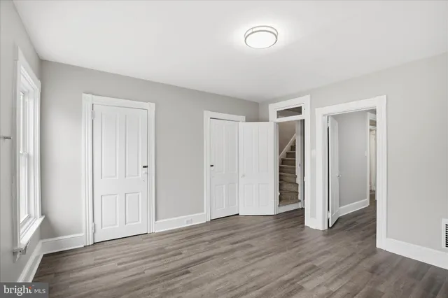 a view of empty room with wooden floor