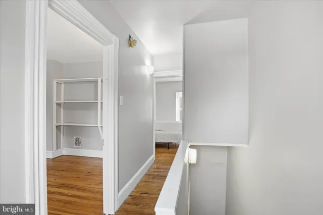 a view of a hallway with wooden floor and staircase
