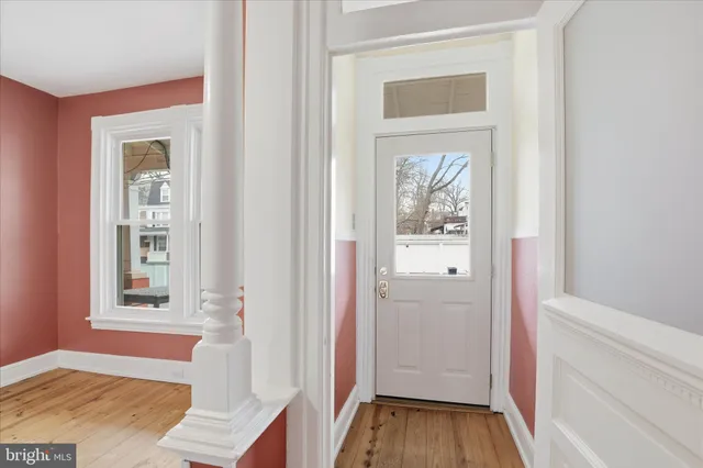 a view of a hallway with wooden floor and a livingroom