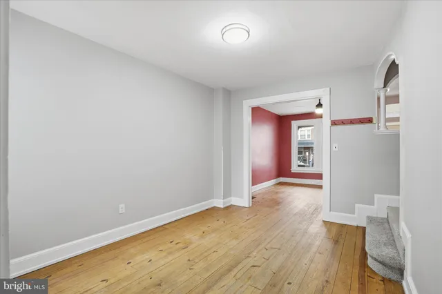 wooden floor in an empty room with a window