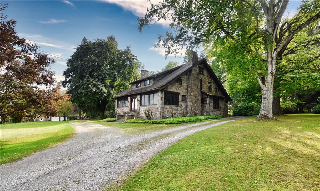 a front view of a house with a yard and trees