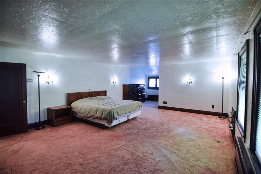 3765 Highway 257 Seneca, PA 16346 - Photo 17 of 42 a spacious bedroom with a bed and a chandelier