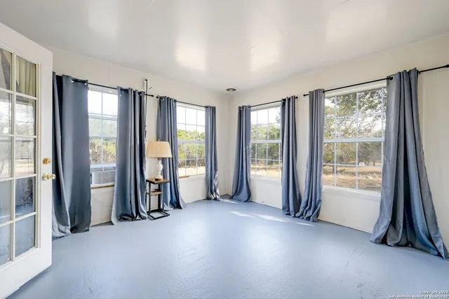 a view of an empty room and bathroom with a large window