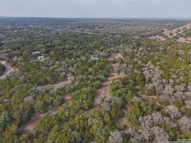 an aerial view of house with yard and mountain view in back