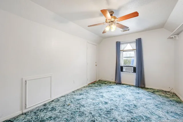 an empty room with closet and ceiling fan