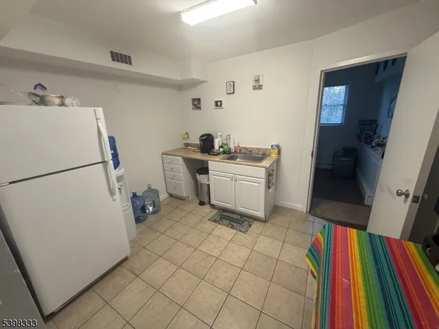 a view of a kitchen with fridge and workspace
