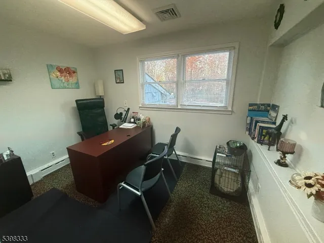 a view of a workspace with furniture and a window