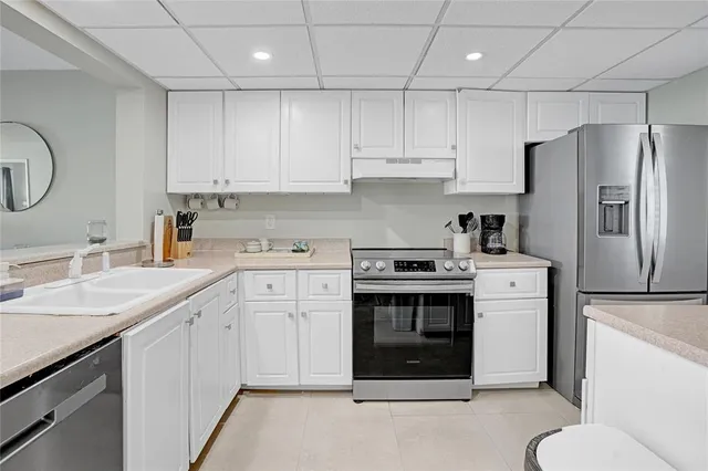 a kitchen with white cabinets and white appliances