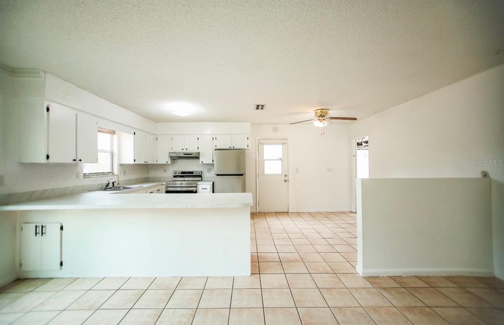 606 Water Road Ocala, FL 34472 - Photo 7 of 34 a kitchen with kitchen island cabinets and refrigerator