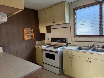 a kitchen with a stove sink and cabinets