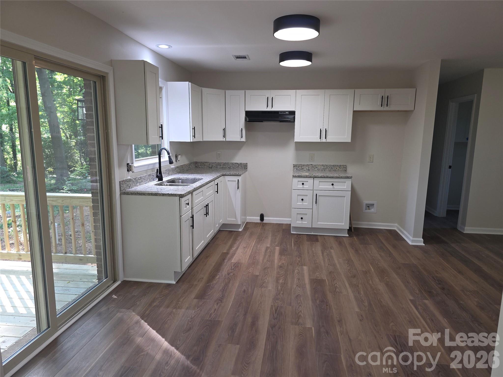 5710 Unionville Road Monroe, NC 28110 - Photo 4 of 18 a kitchen with wooden floors and white cabinets