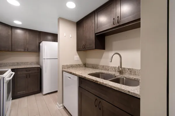 a bathroom with a granite countertop sink toilet a large mirror a shower and a bathtub