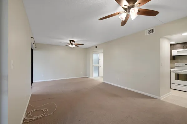 an empty room with windows and fan