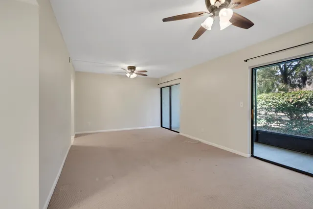 an empty room with chandelier fan