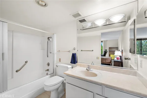 a bathroom with a sink and mirror with toilet