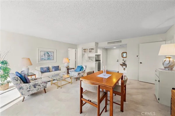 a living room with furniture and a dining table with chairs
