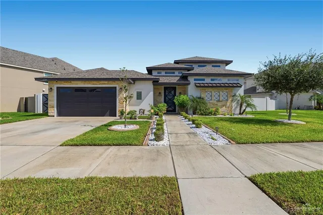 a front view of a house with a yard and potted plants