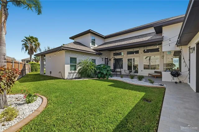 a view of a house with backyard and sitting area