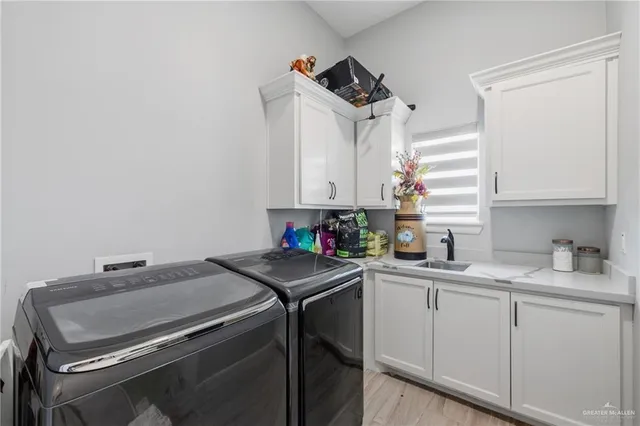 a utility room with sink dryer and washer