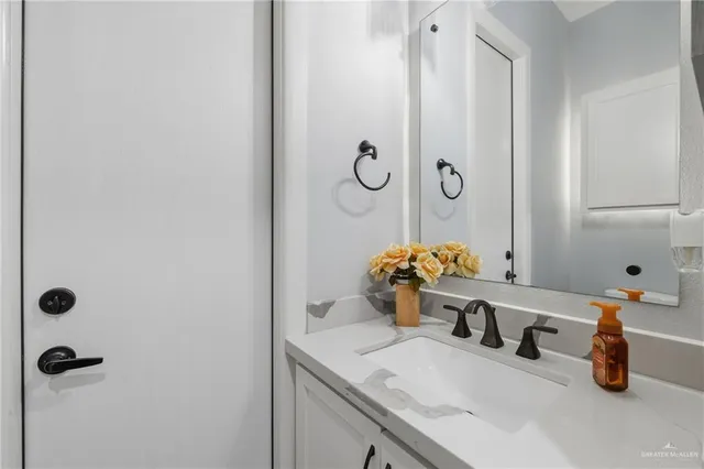 a bathroom with a sink mirror and vanity