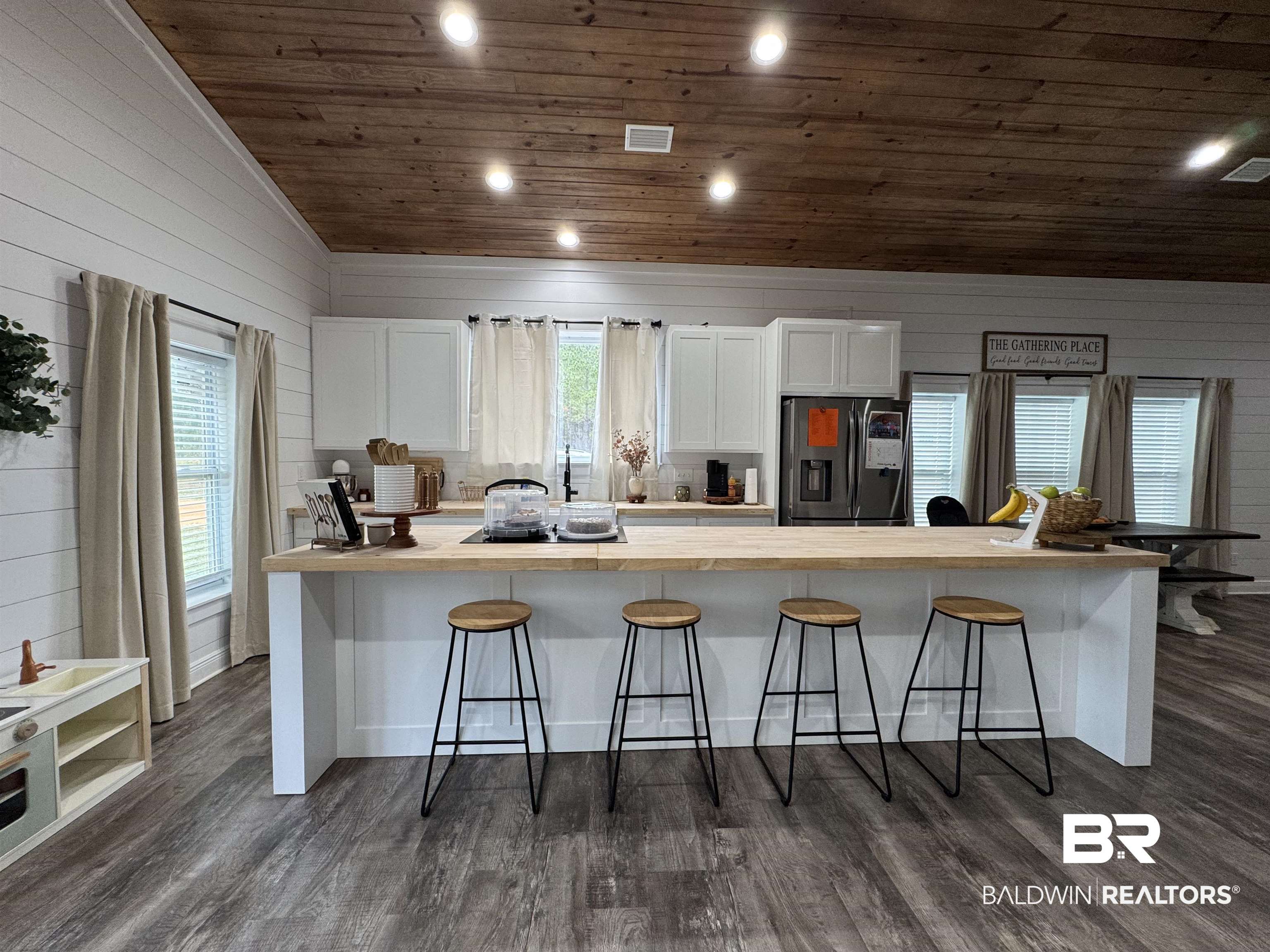 370 Dianne Road Frisco City, AL 36445 - Photo 9 of 41 Kitchen featuring white cabinets, a kitchen breakfast bar, and stainless steel fridge