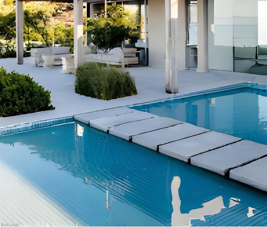 415 Seabee Avenue Naples, FL 34108 - Photo 20 of 32 a view of a swimming pool with an outdoor seating
