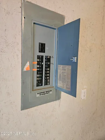 a view of a refrigerator in kitchen and an empty room