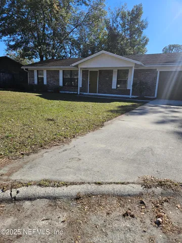 a front view of a house with a yard and trees