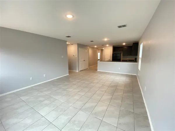 an empty room with kitchen and chandelier