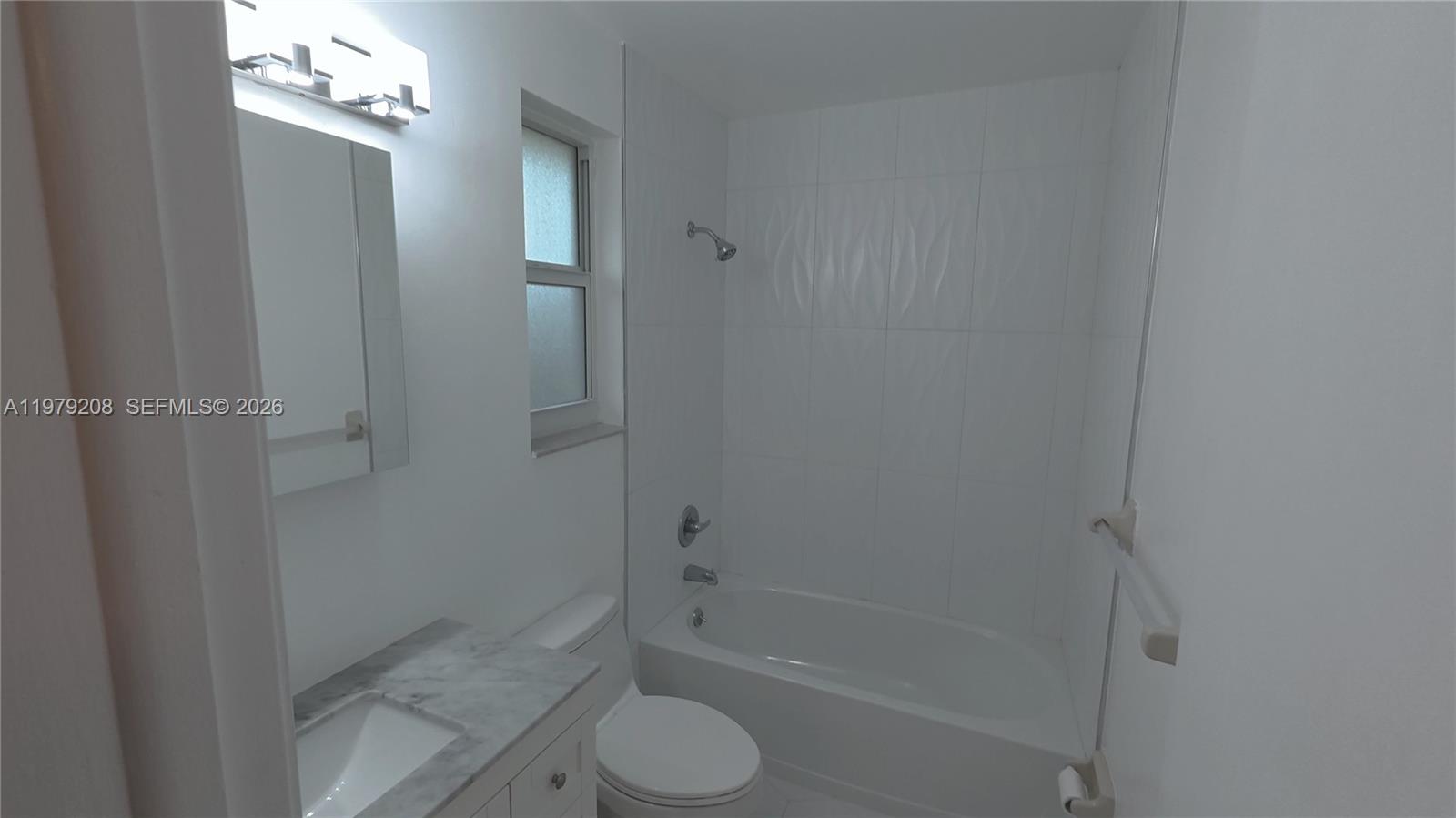 7121 Southwest 129th Avenue, Unit 8 Miami, FL 33183 - Photo 12 of 13 a bathroom with a granite countertop bathtub shower and toilet