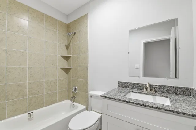 a bathroom with a granite countertop sink toilet and shower