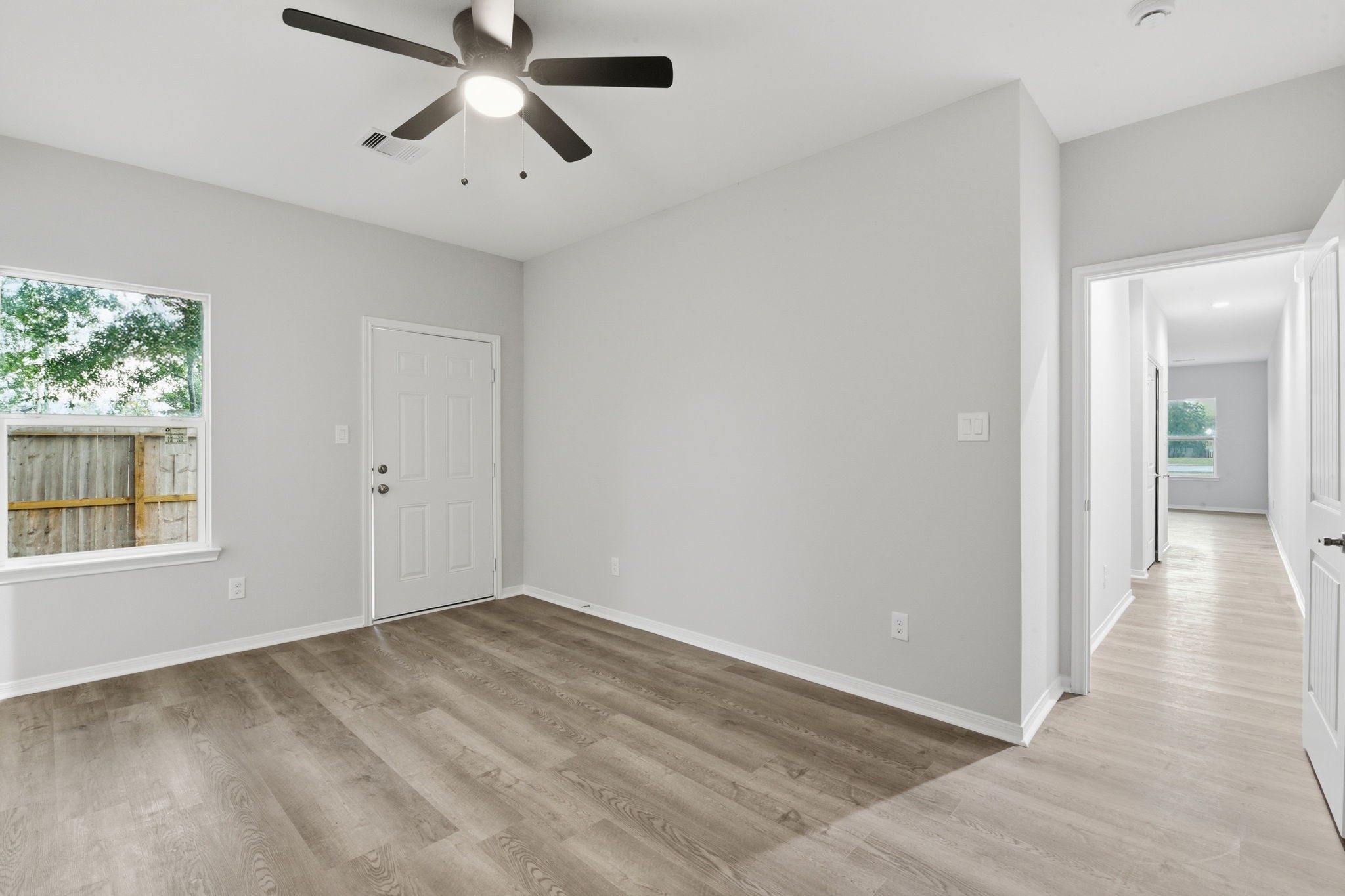 2521 Maple Street, Unit 2521B Liberty, TX 77575 - Photo 19 of 26 wooden floor in an empty room with a window
