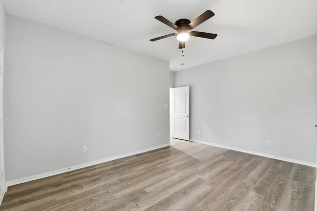 an empty room with a window and a fan