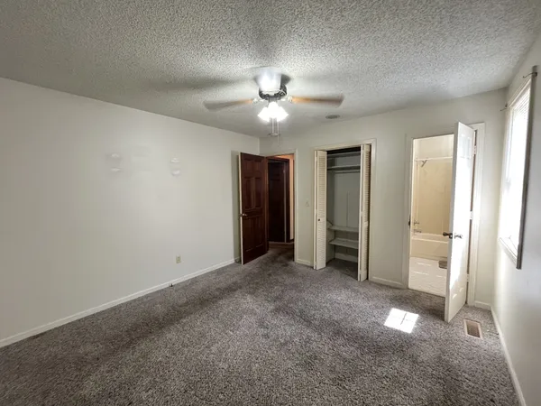 a bathroom with a granite countertop toilet and a sink