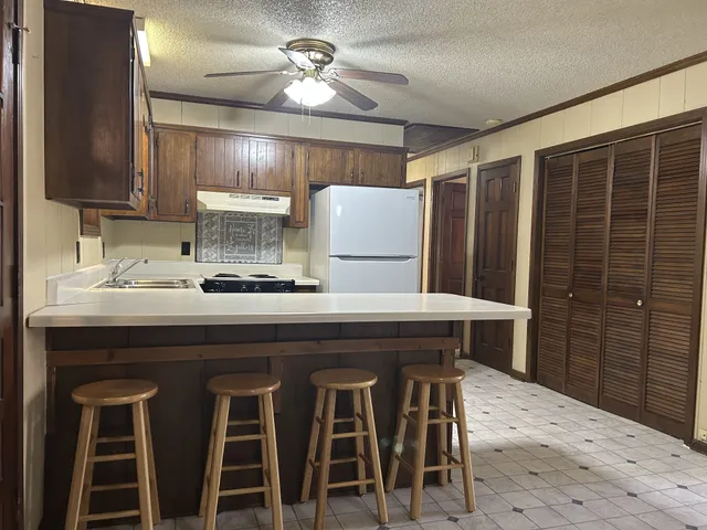 a kitchen with a table chairs refrigerator and cabinets