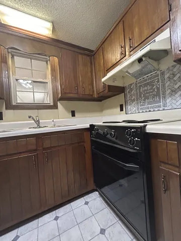 a kitchen with a sink stove and cabinets