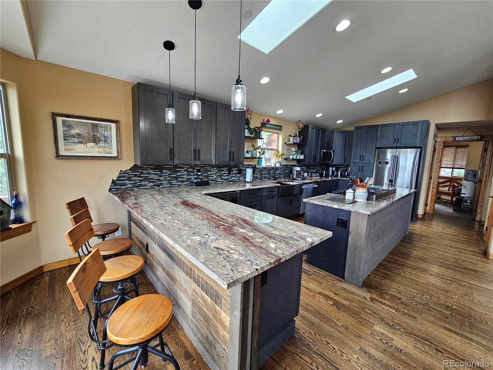 14514 Reserve Road Pine, CO 80470 - Photo 11 of 31 a kitchen with kitchen island a stove and a wooden floors