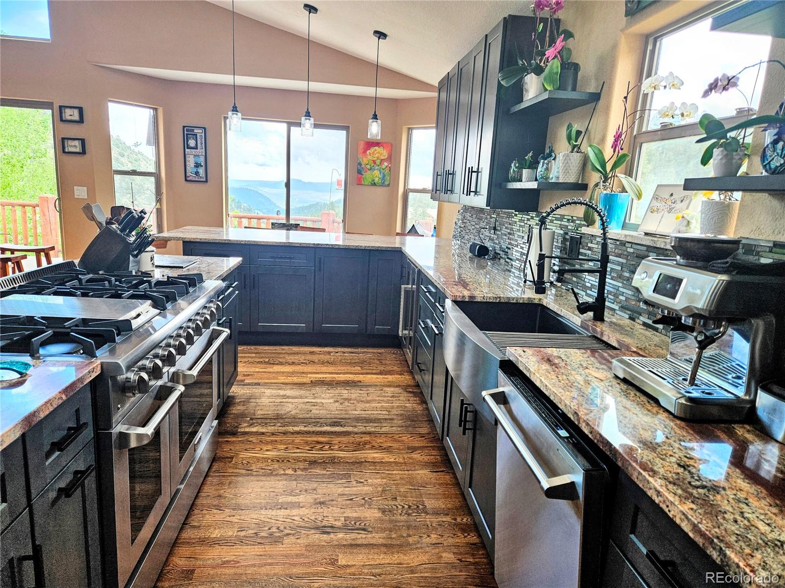14514 Reserve Road Pine, CO 80470 - Photo 13 of 31 a kitchen with stainless steel appliances granite countertop a stove a sink and a wooden floors
