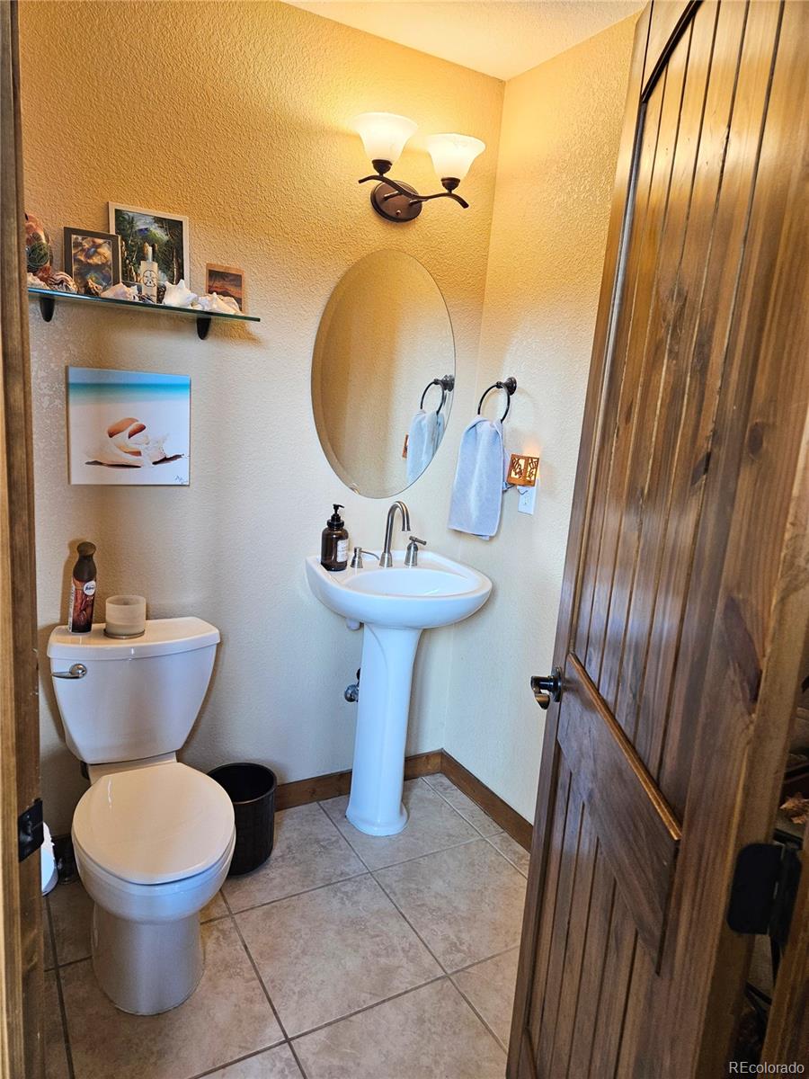 14514 Reserve Road Pine, CO 80470 - Photo 18 of 31 a bathroom with a sink toilet and mirror