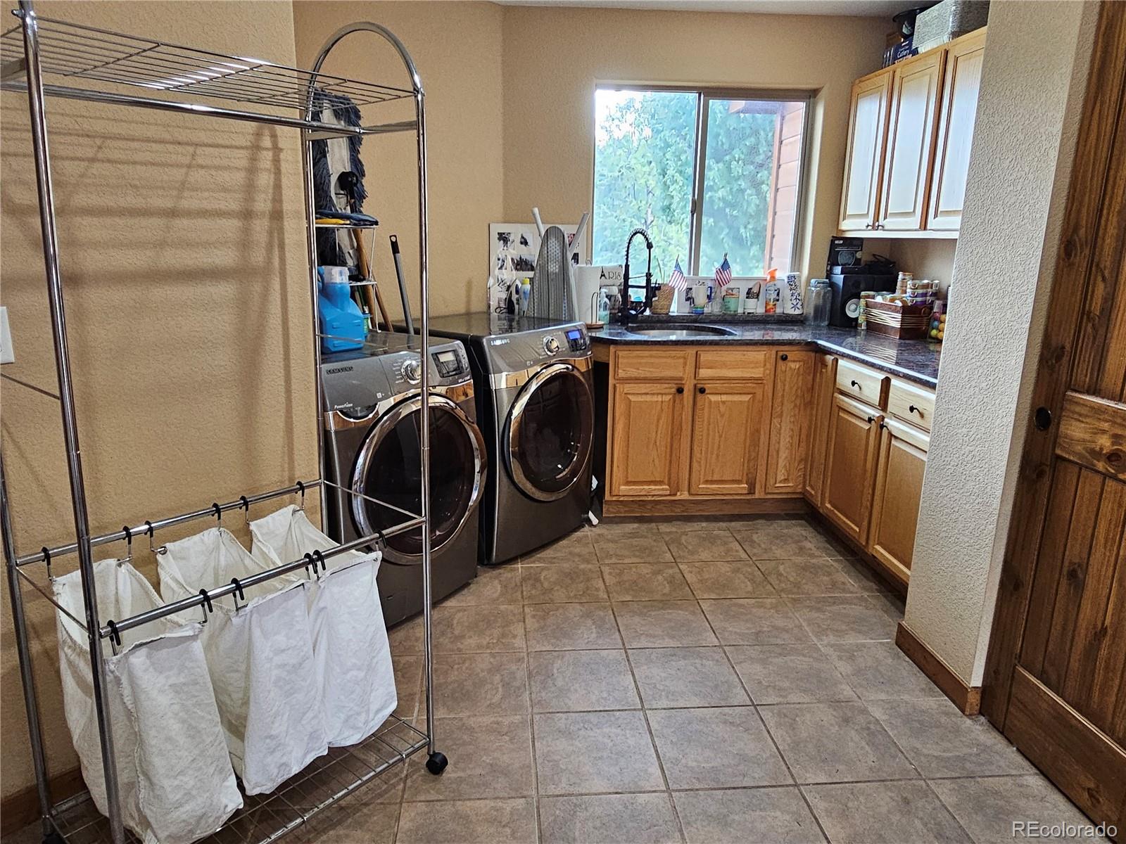 14514 Reserve Road Pine, CO 80470 - Photo 19 of 31 a utility room with cabinets washer and dryer