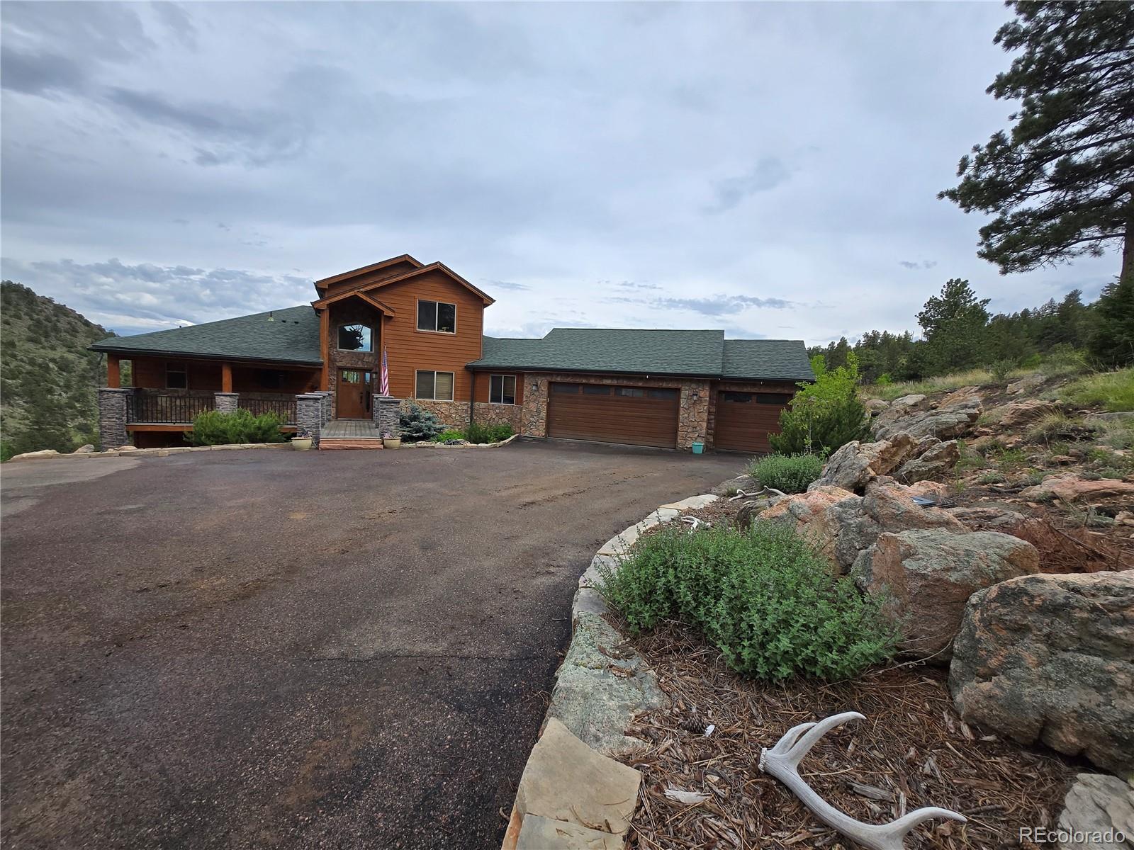 14514 Reserve Road Pine, CO 80470 - Photo 2 of 31 a view of a house with a yard and potted plants