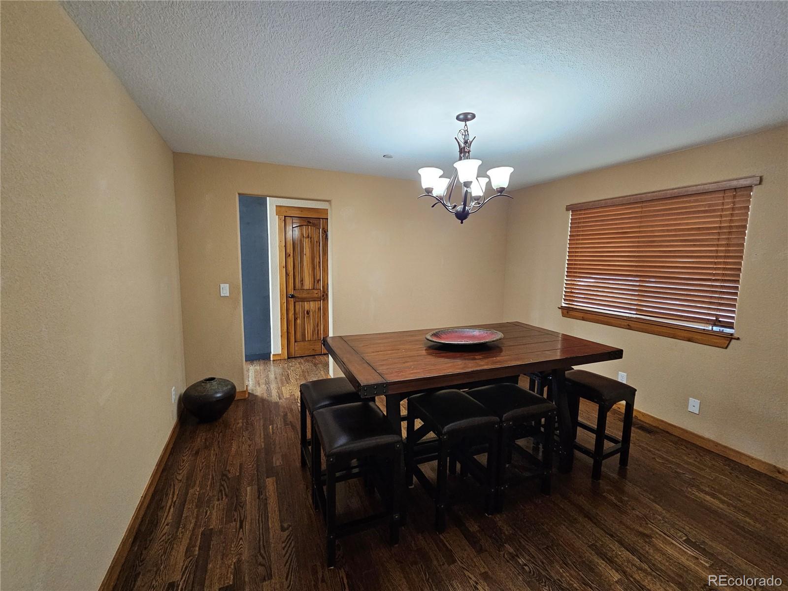14514 Reserve Road Pine, CO 80470 - Photo 27 of 31 a view of a dining room with furniture and wooden floor