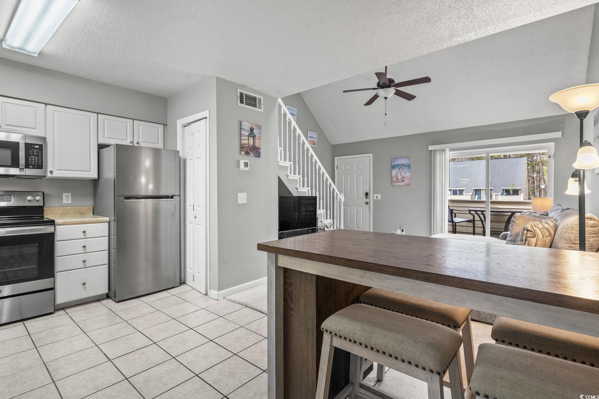 416 Cambridge Circle, Unit H5 Murrells Inlet, SC 29576 - Photo 4 of 28 Kitchen featuring white cabinetry, vaulted ceiling