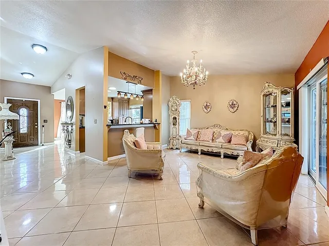 a living room with furniture a chandelier and a dining table