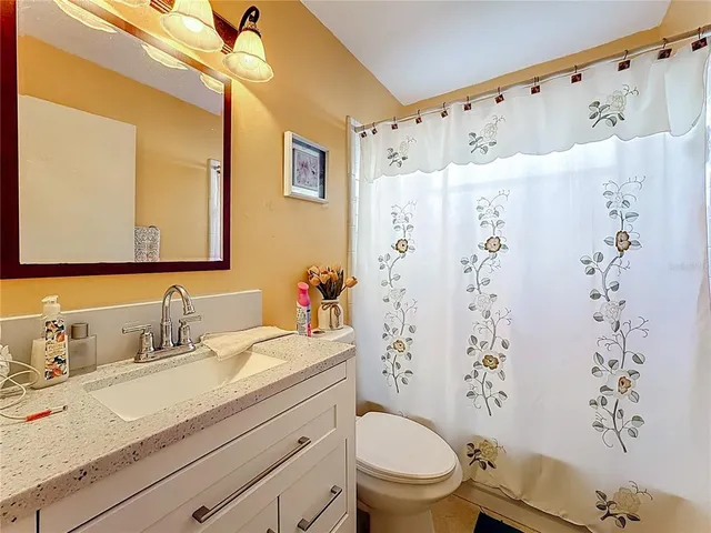 a bathroom with a granite countertop sink toilet and shower