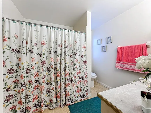 a bathroom with a sink toilet and shower curtain