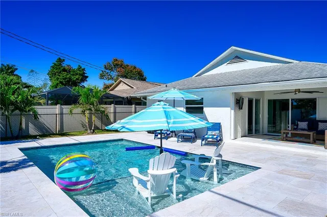 a patio with a table and chairs under an umbrella