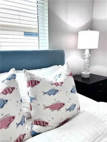 a view of a bedroom with a bed and a lamp