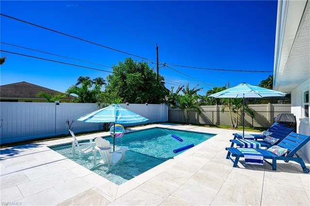 a view of a patio with couches chairs and a table and chairs with plants and trees