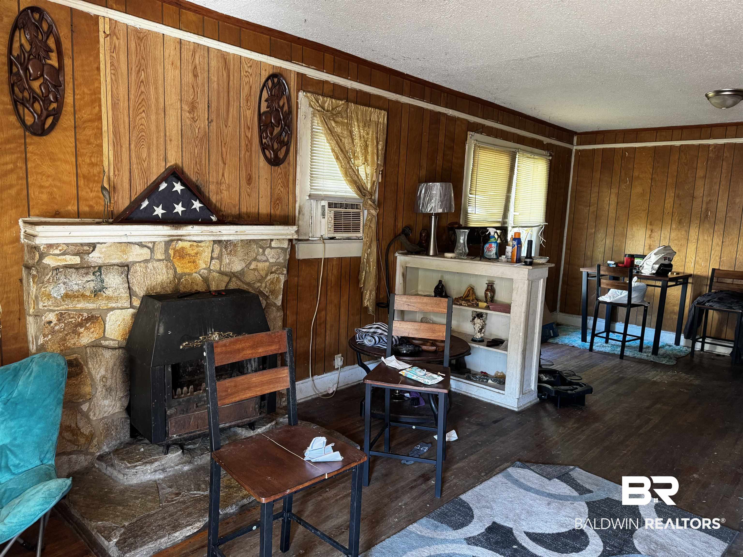 1060 Cottrell Street Mobile, AL 36605 - Photo 5 of 6 Living room featuring cooling unit, wood walls, a fireplace, and dark hardwood / wood-style flooring